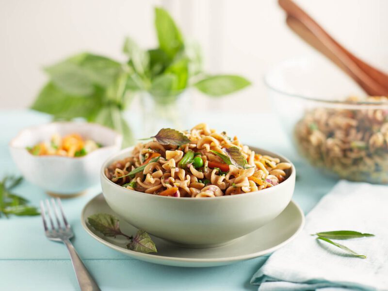 Easy Vegan Pasta Salad in a white bowl sitting on a white plate