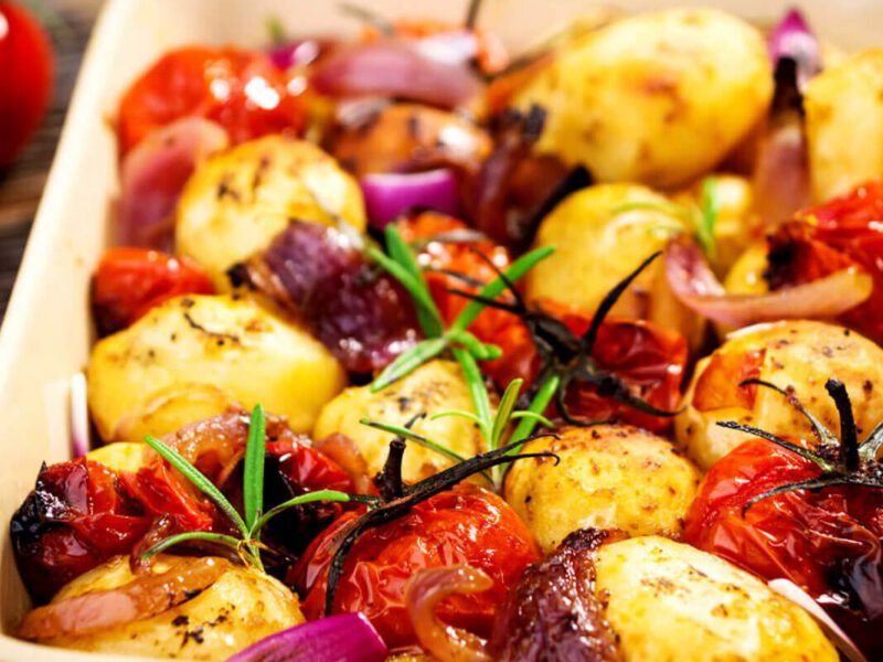 Potato and Onion Bake with Rosemary and Tomatoes in a casserole dish
