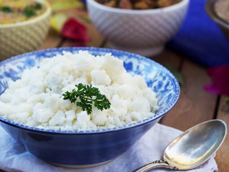 Mashed potatoes in a blue bowl on a white cloth napkin