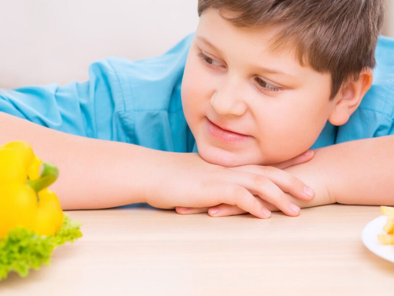 Boy deciding between health food and junk food