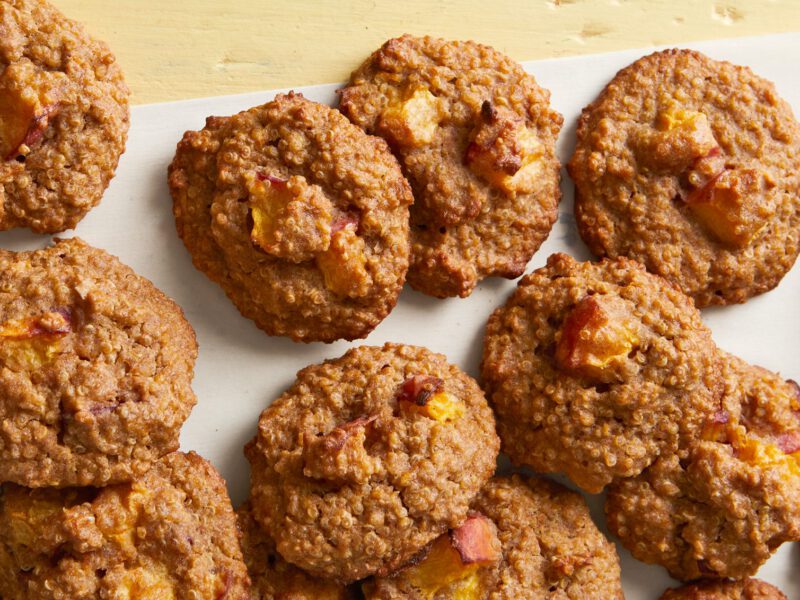 More than a dozen Stone Fruit and Quinoa Breakfast Cookies on parchment paper