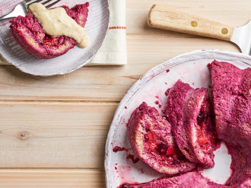 Summer Pudding with Fresh Berries and Lavender Cashew Cream on a round platter with one serving on a small plate