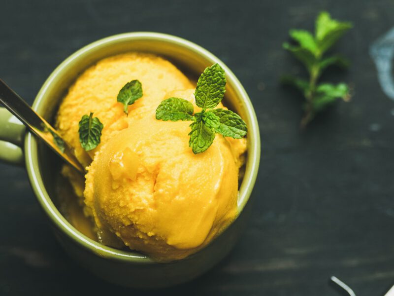 Mango Nice Cream in a green mug garnished with a sprig of fresh mint