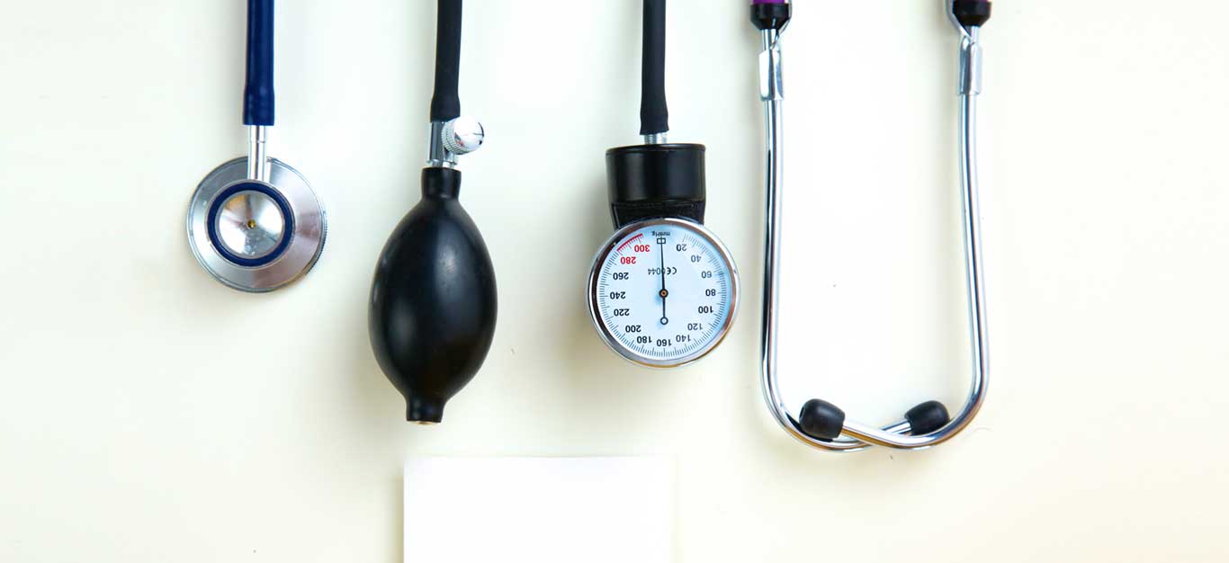 A stethoscope and blood pressure cuff laid out on a white table