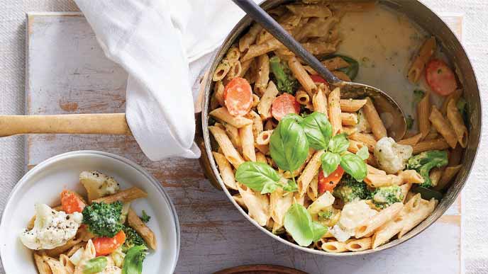 Pasta Primavera in a soup pot with a metal spoon