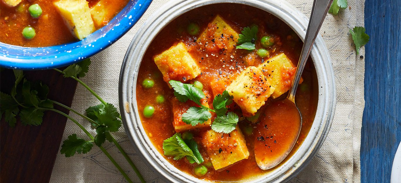Polenta Curry - Hearty red stew with cubes of polenta and green peas and other veggies