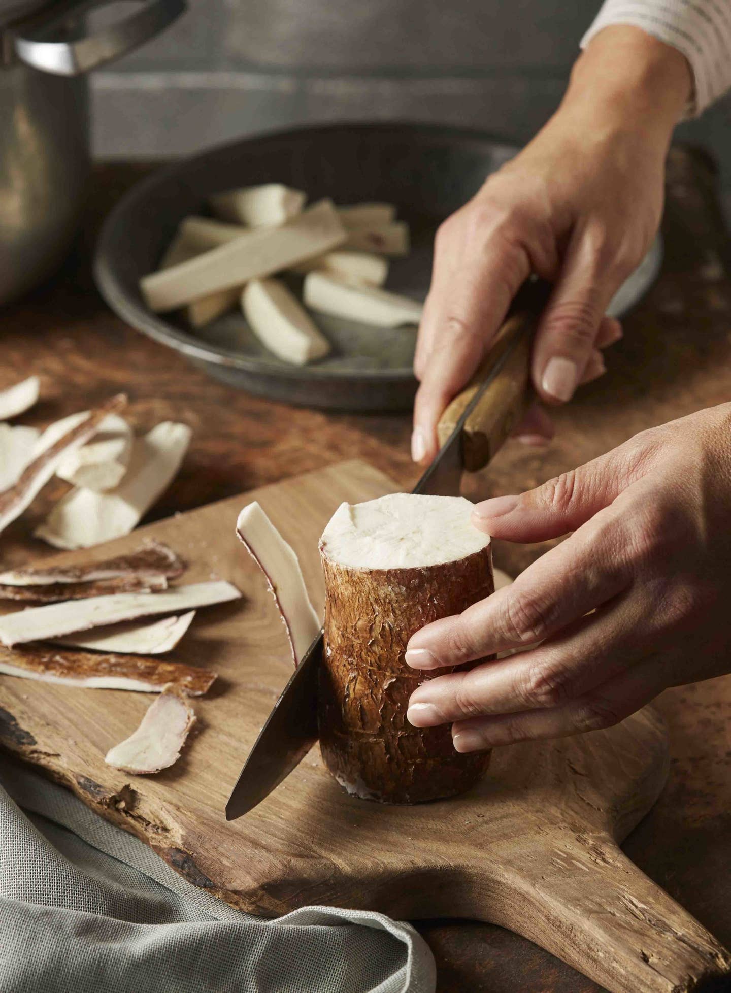 Close up of a person slicing yuca