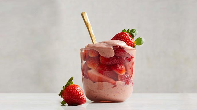 The Best Vegan Strawberries and Cream in a glass cup with a gold spoon